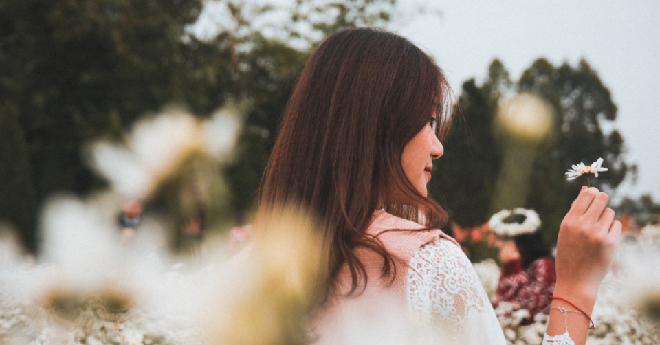 a woman in a field of daisies