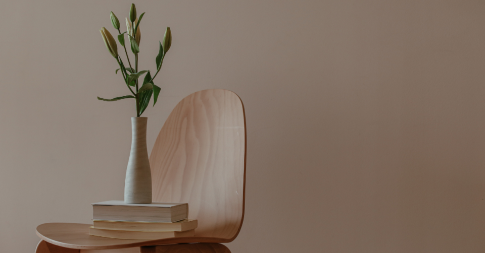 a chair with books and a vase on top