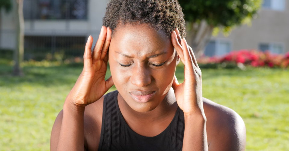 a woman holding her head with a migraine