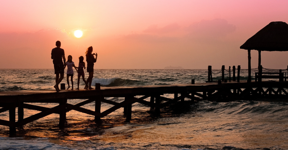 a family on vacation on a beach at sunset