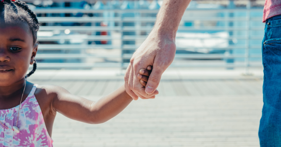 little girl holding a man's hand