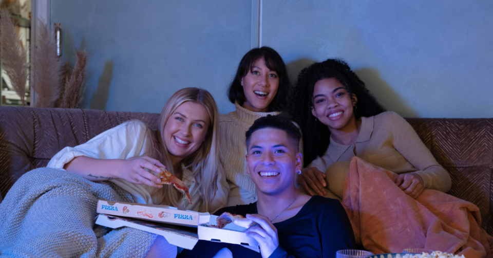 4 people smiling watching a movie