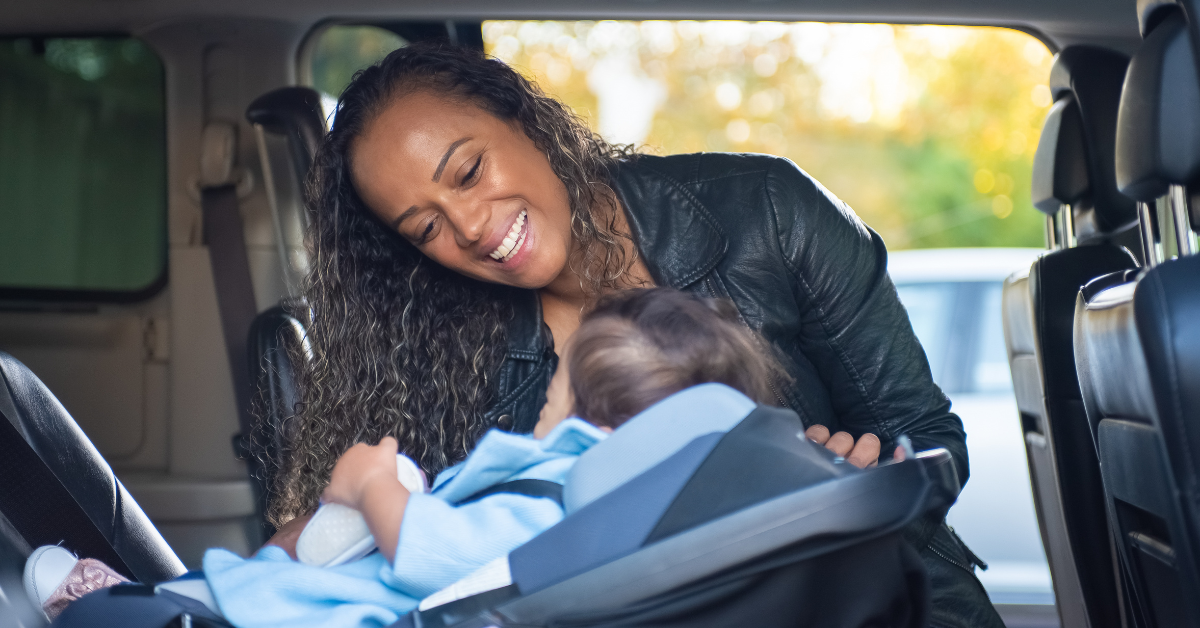 child in car seat with smiling mum