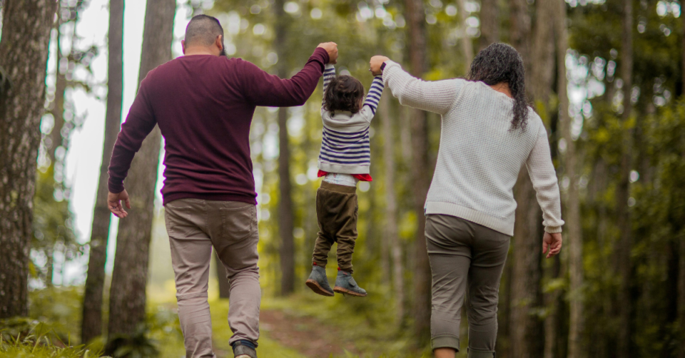 two parents lifting a child