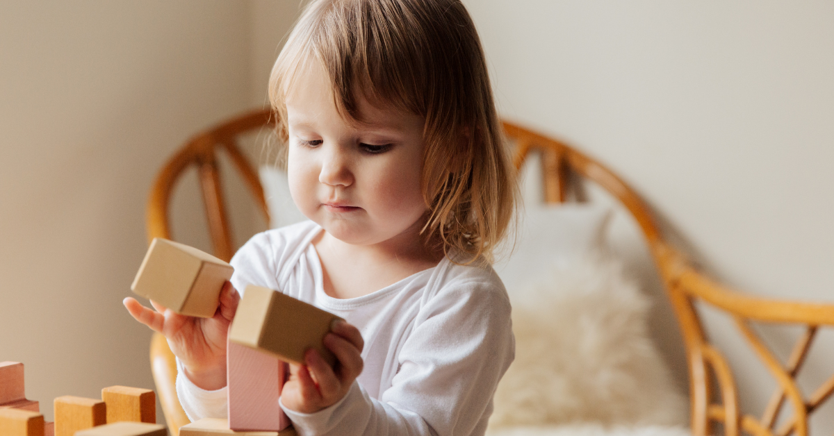 a child holding building blocks