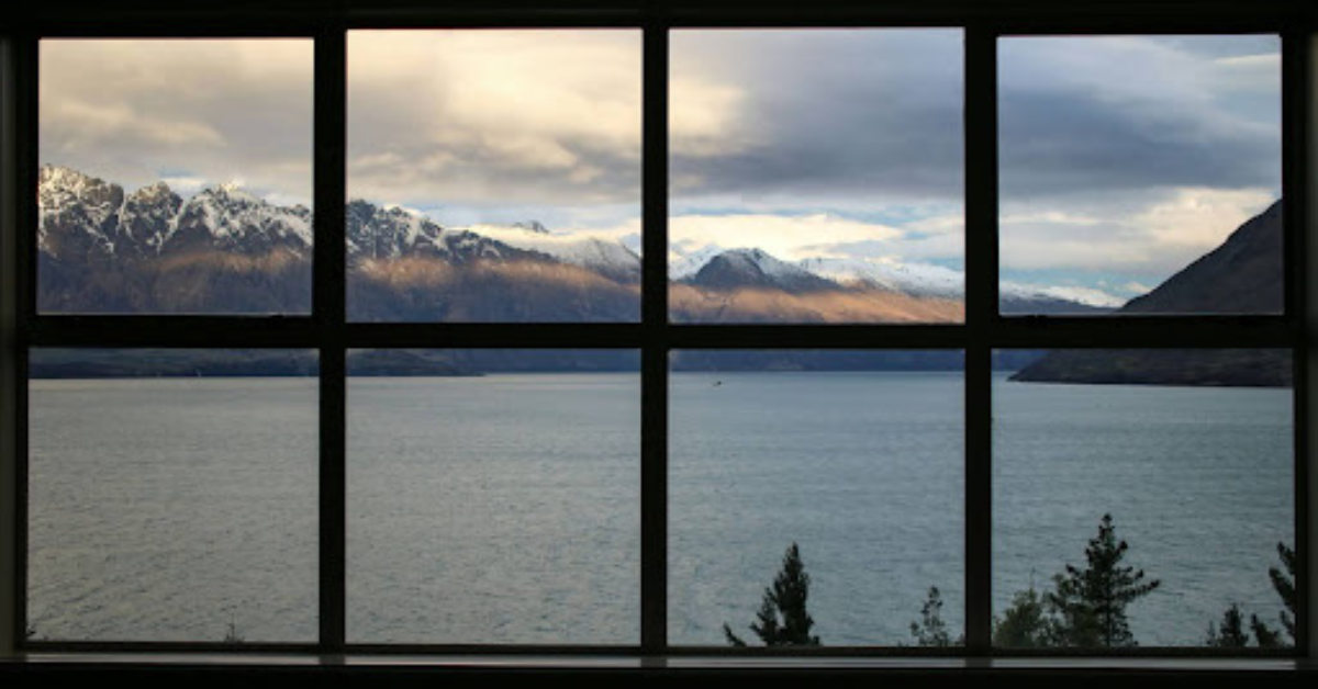 a large black window looking out onto a lake