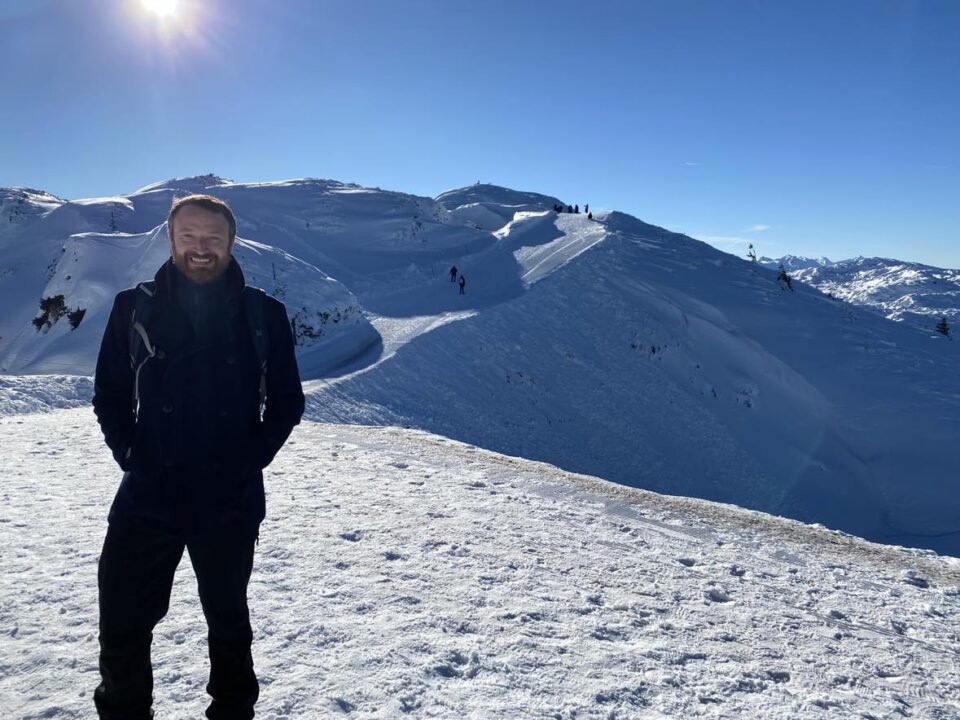 my husband stood at the top of the snowy mountain