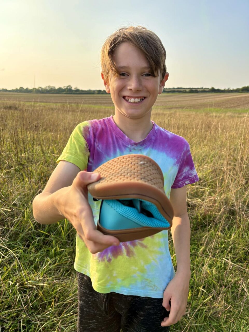 a child showing the flexibility of the Feelgrounds shoes by folding one in half 