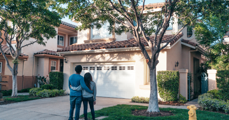 a couple outside a house looking up at it