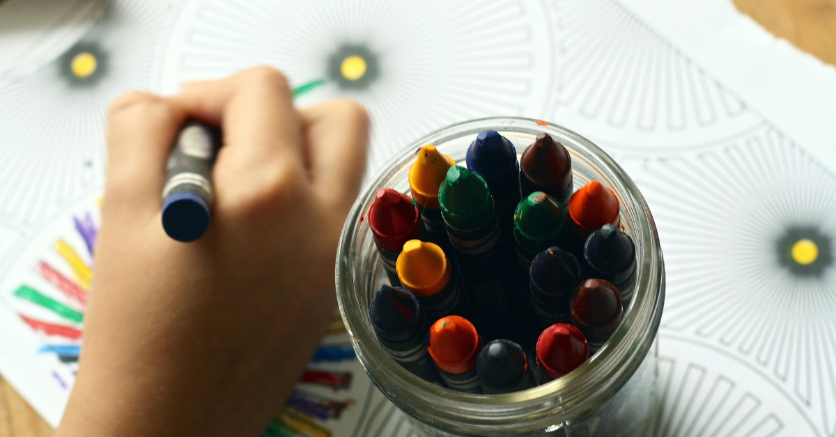 a kid using crayons