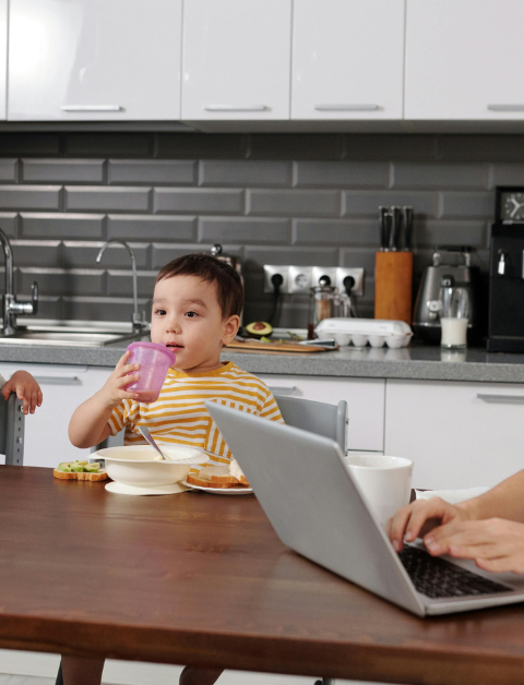 mum and kids in kitchen with mu on the phone and laptop