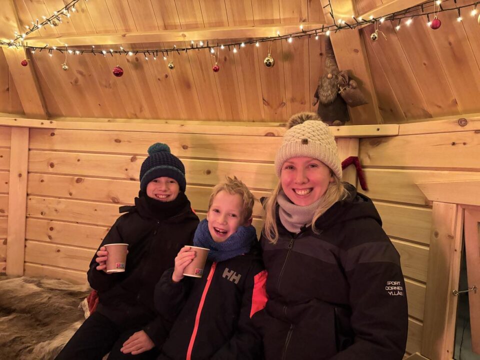 me and my two children in the hot chocolate hut at the searching for santa experience