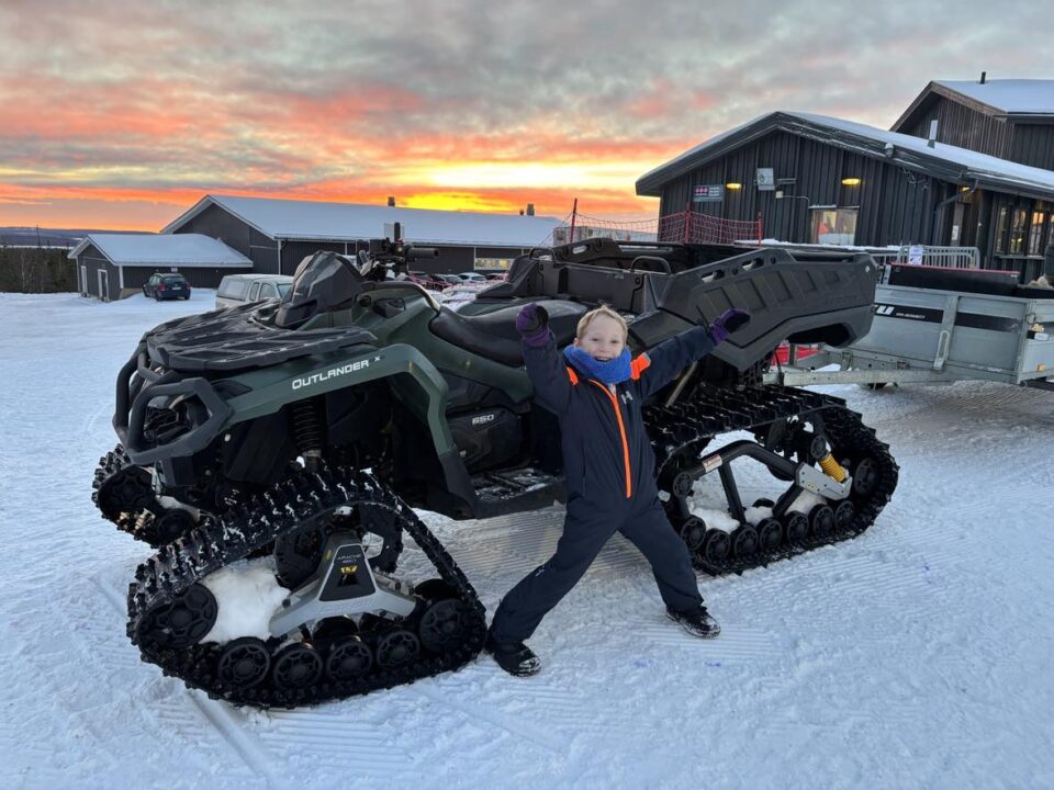 my youngest next to a snowmobile he thought was very cool