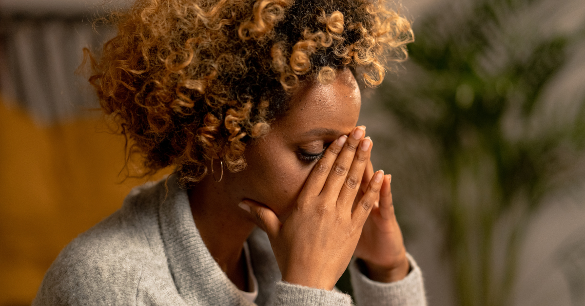 a lady with her hands up to her face implying she has anxiety