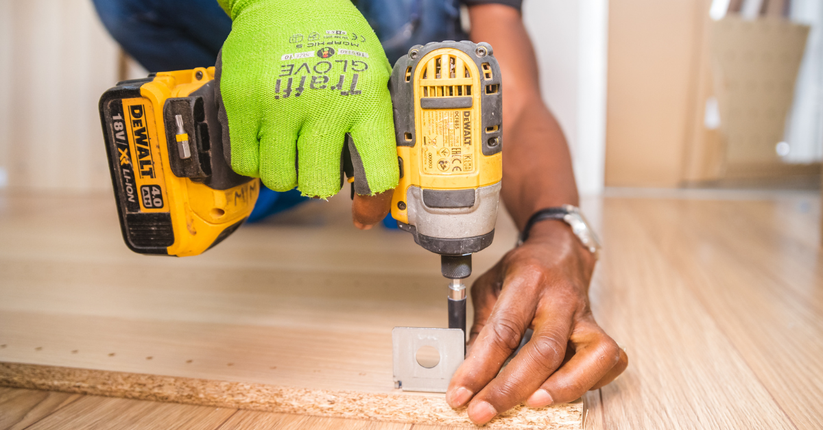 a person doing DIY by drilling and wearin safety gloves