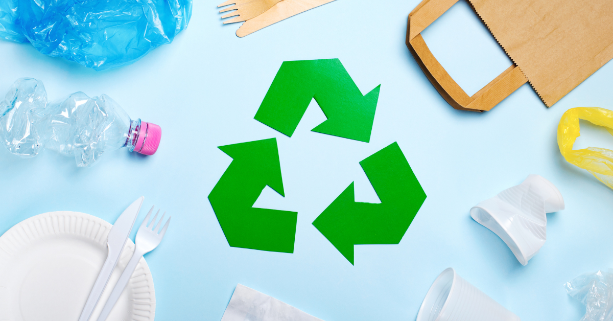 a recycling sign with plastics waste around it