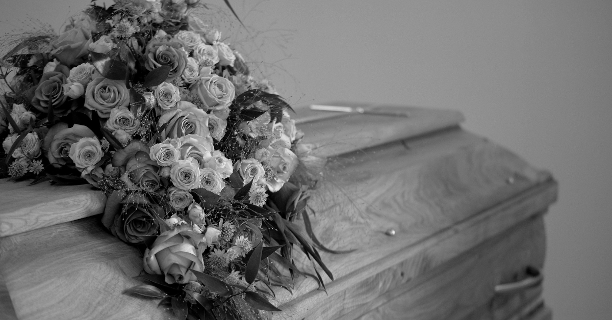 a coffin and flowers at a funeral black and white photo