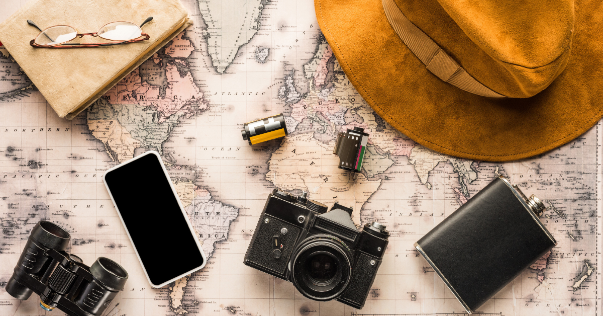 travel items like a map, camera, film and hat