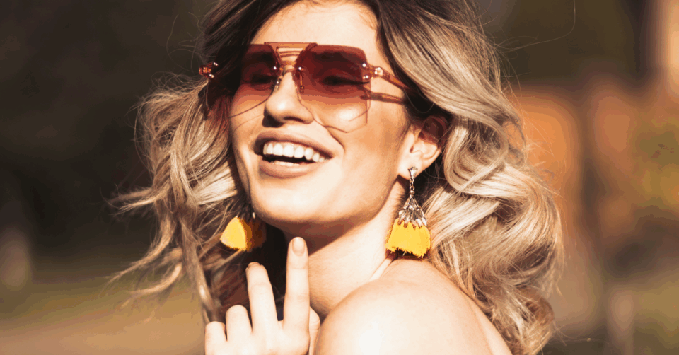 a happy blonde lady wearing big bold earrings