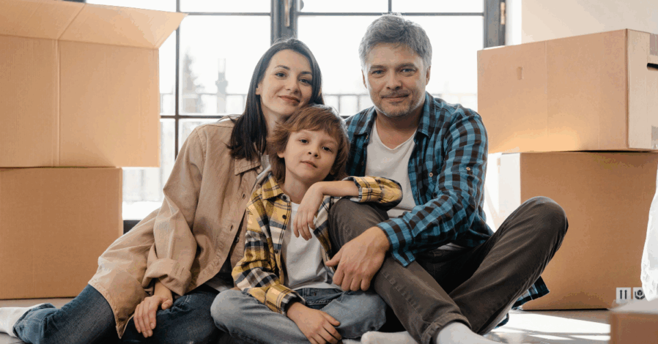 a family next to moving boxes
