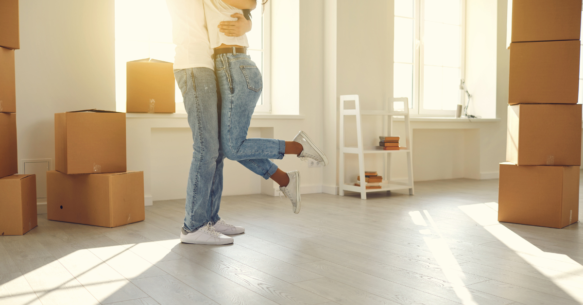 2 people in a new home with moving boxes around them