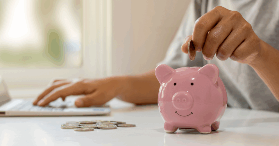 someone putting money in a piggy bank