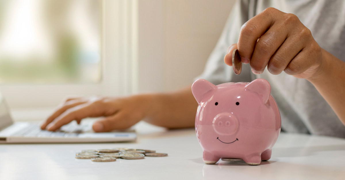 someone putting money in a piggy bank