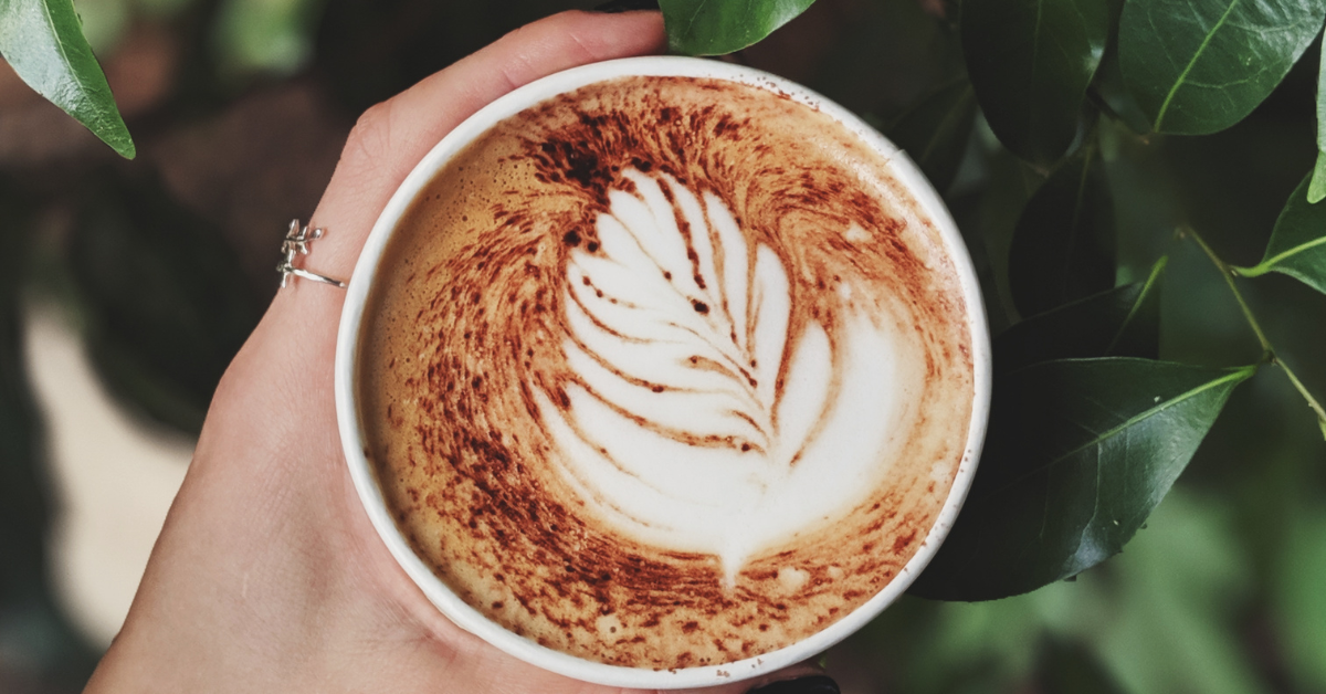 coffee in a cup with a lead design on the top