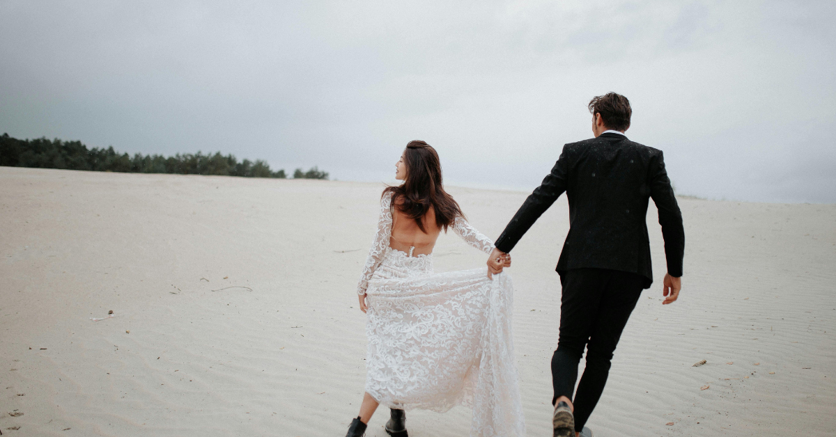 two people in wedding outfits on a beach