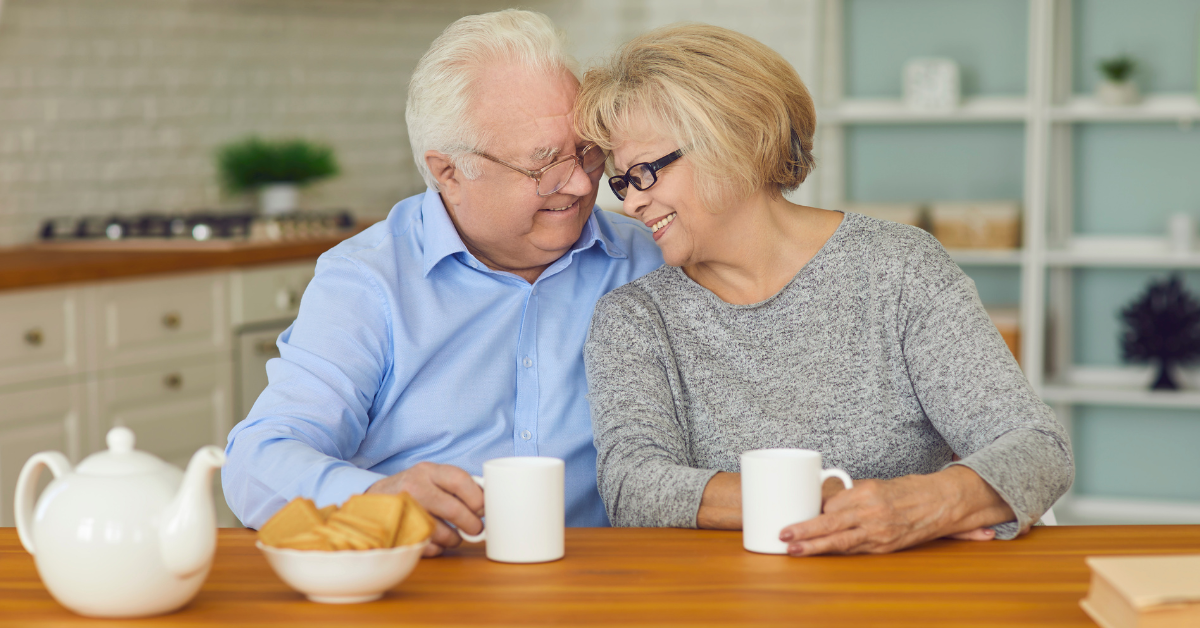 a retired couple in a kitchen looking happy