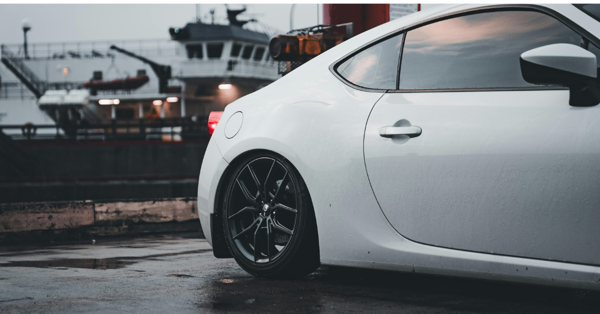 a white car next to a ship