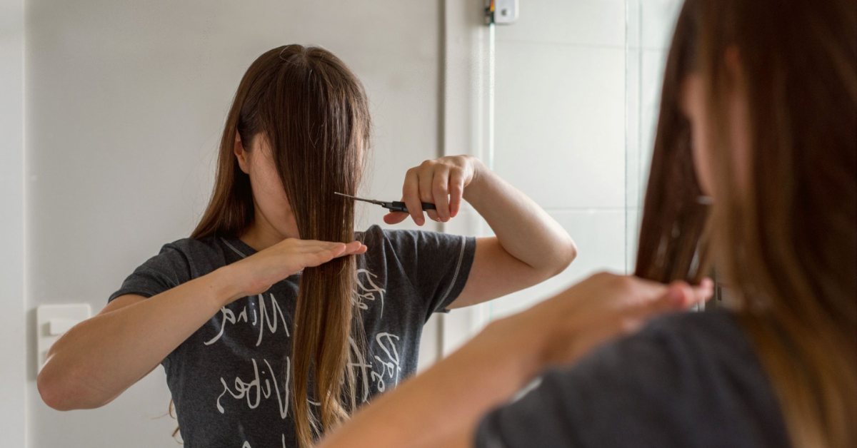 a woman cutting her hair