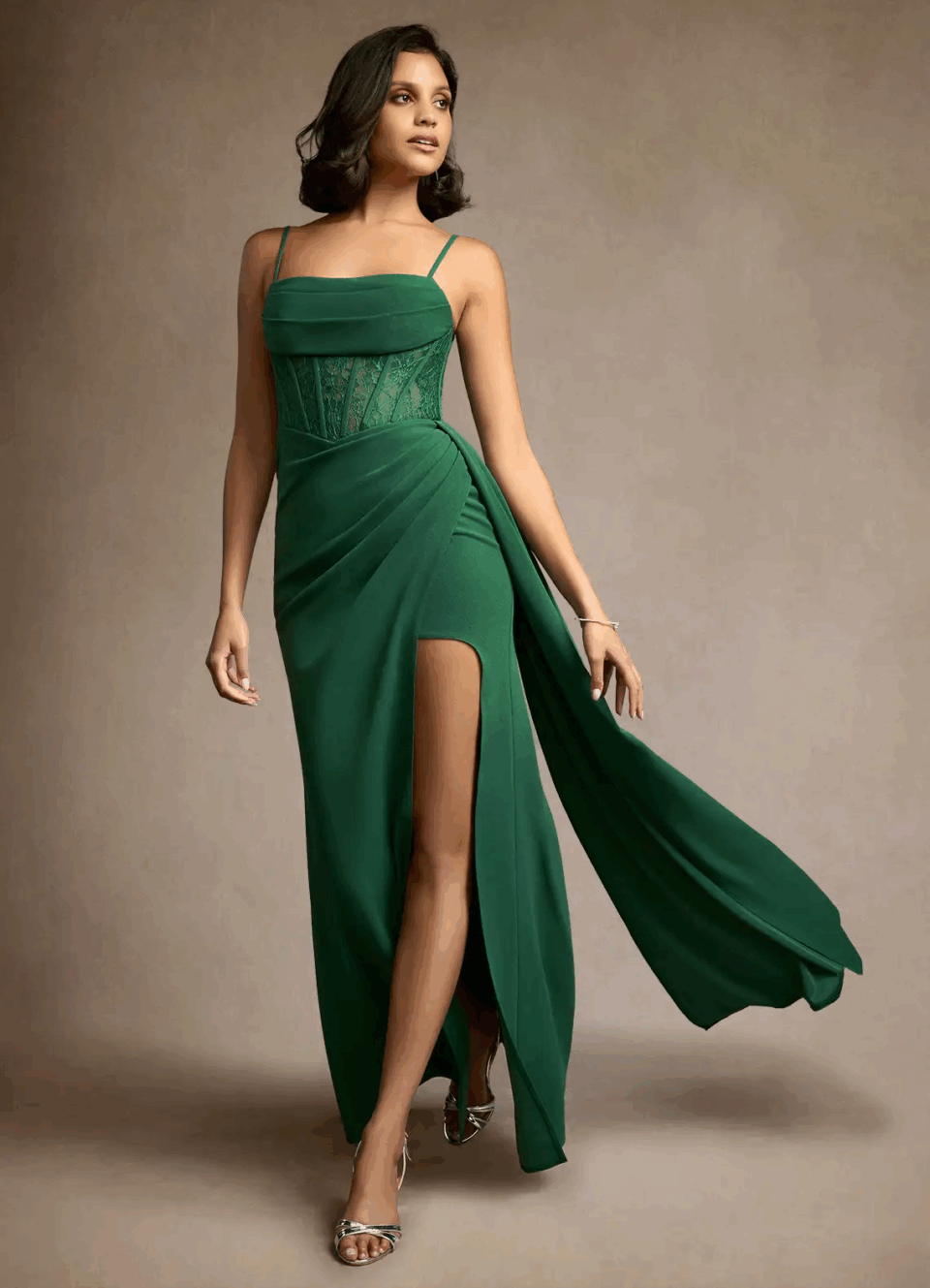 a long green party dress with small straps and a slit on the leg