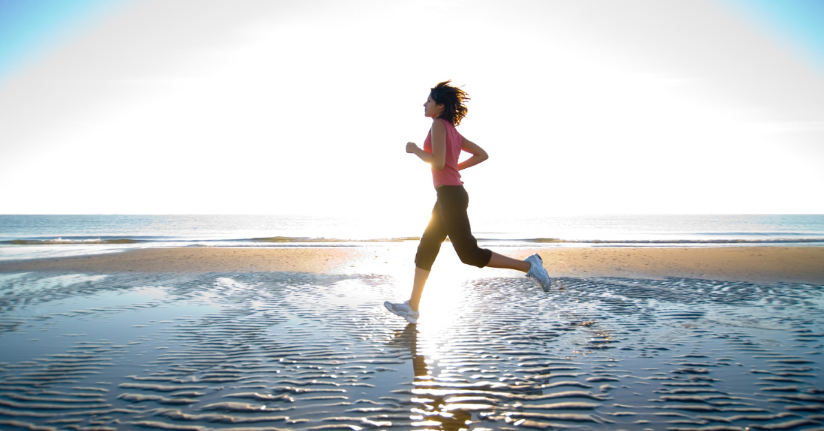 a woman running on a beach