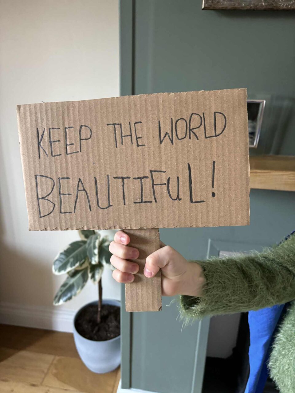 keep the world beautiful! written on a cardboard sign