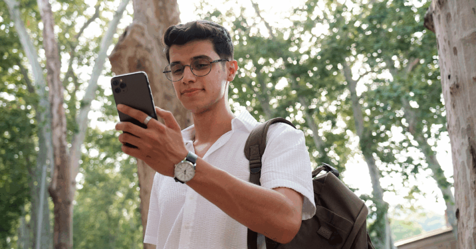 a man looking at his phone outside
