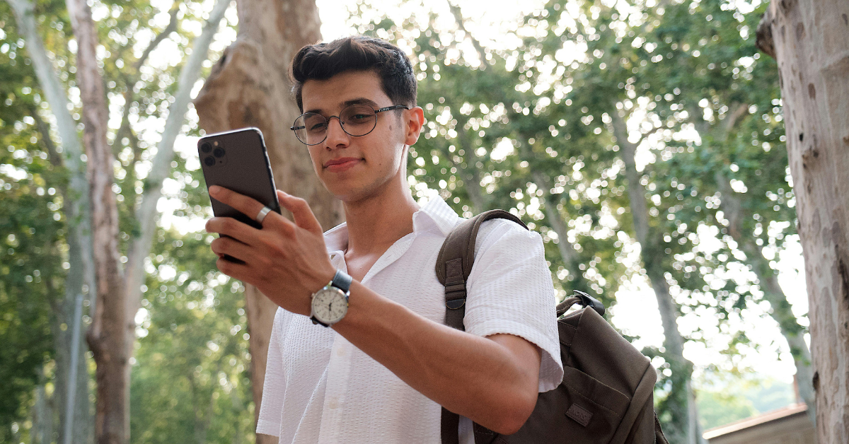 a man looking at his phone outside