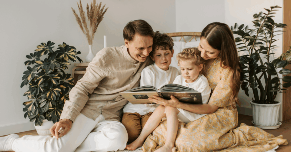a family smiling and looking at a photo album