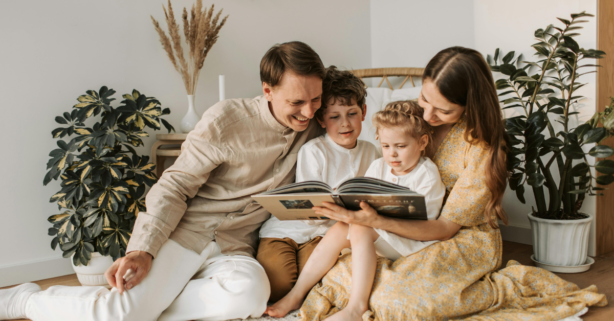 a family smiling and looking at a photo album