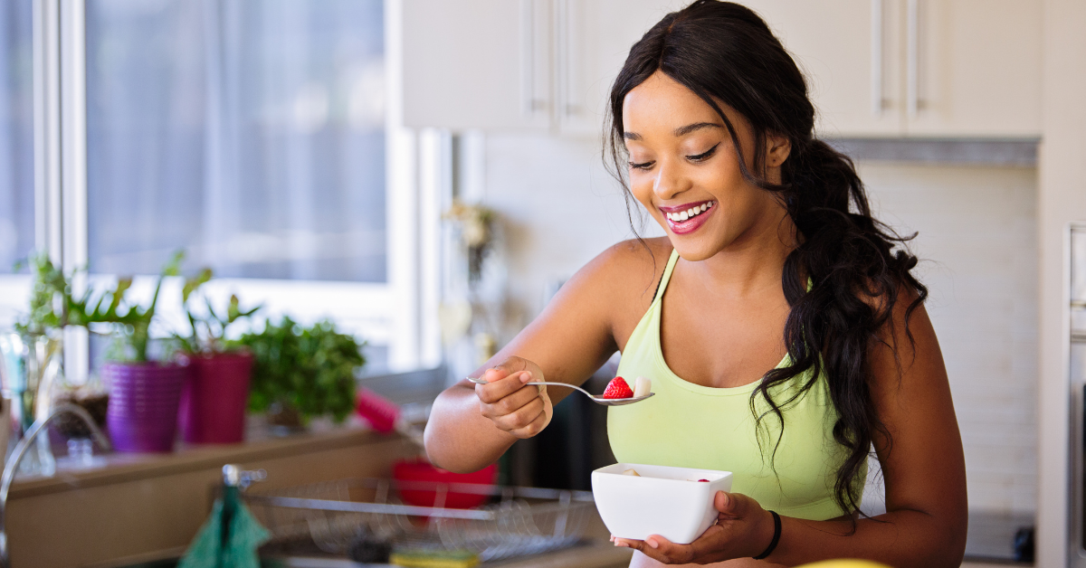 a woman looking healthy and smiling as she eats fruit