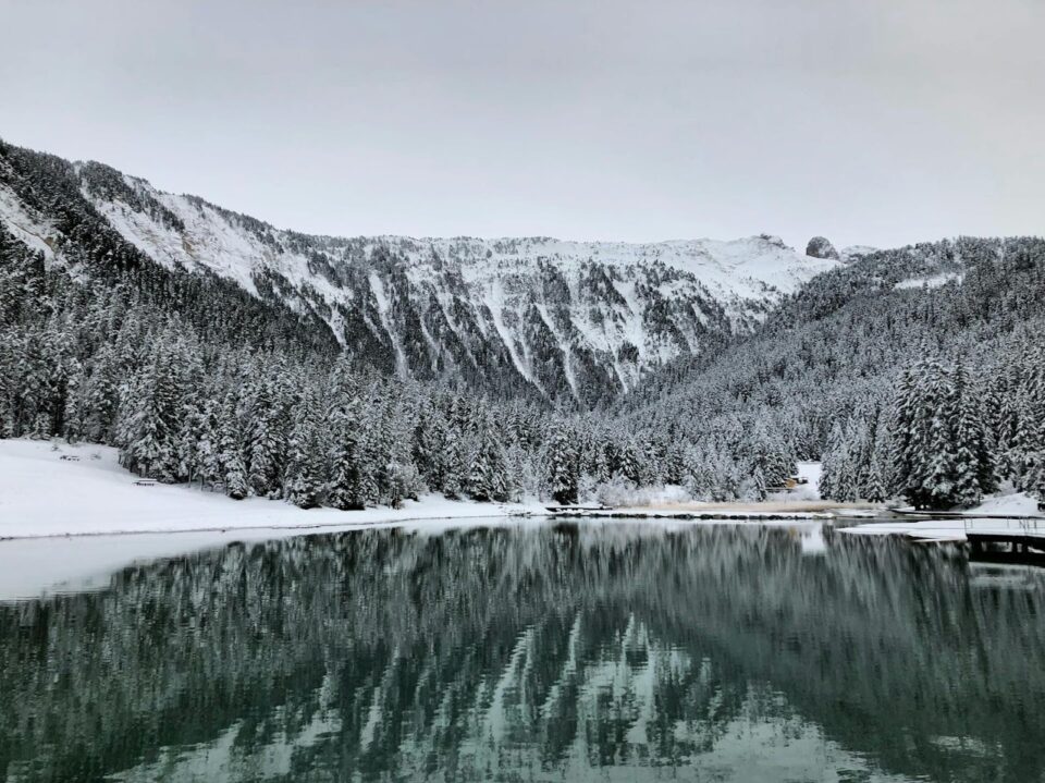 snowy hills with a lake and trees