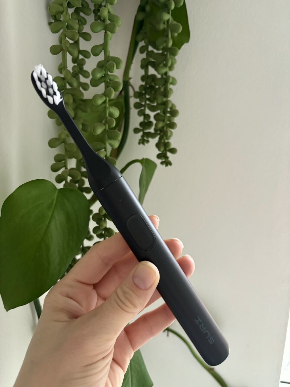 a black SURI toothbrush