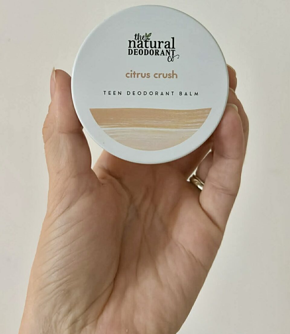 The Natural Deodorant Co citrus crush teen deodorant balm being held up