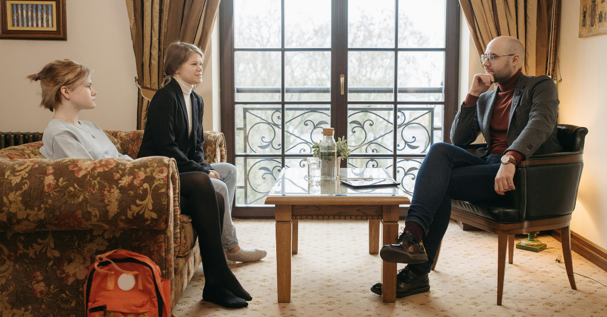a man listening to two women