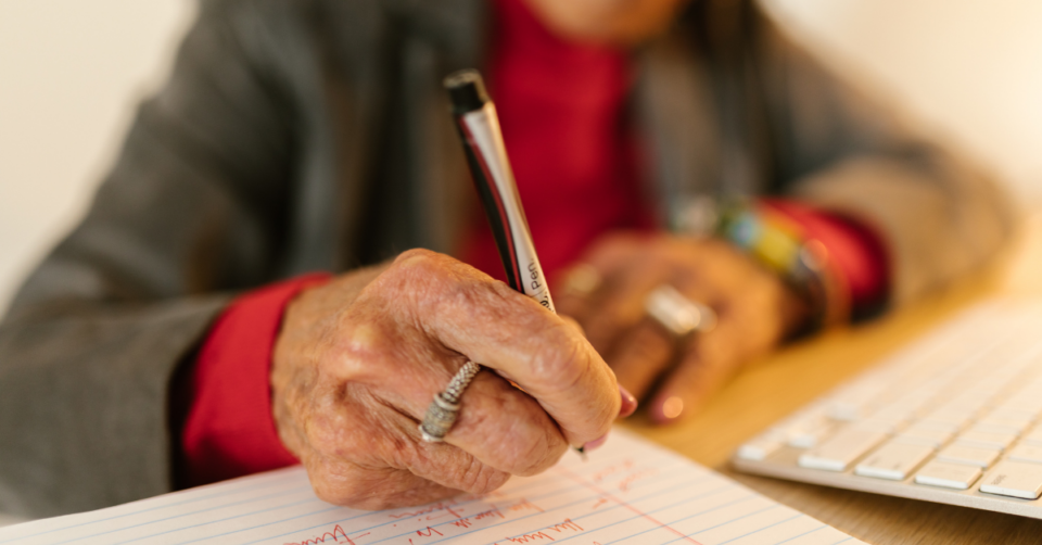 an elderly person writing