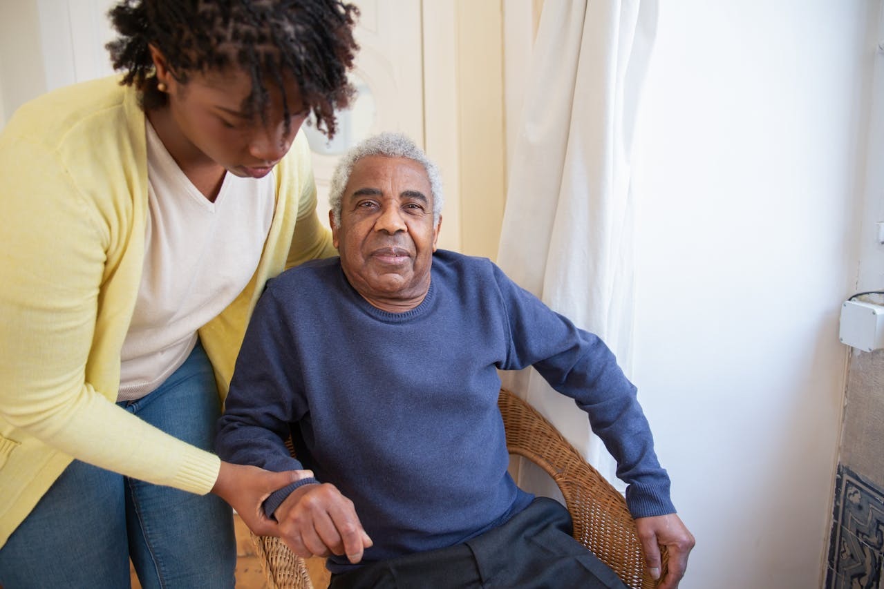 a woman helping a man in a chair