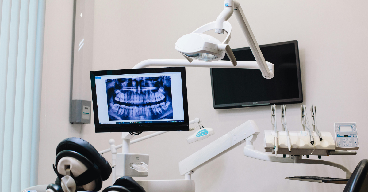 a dentists room with chair and light and an xray