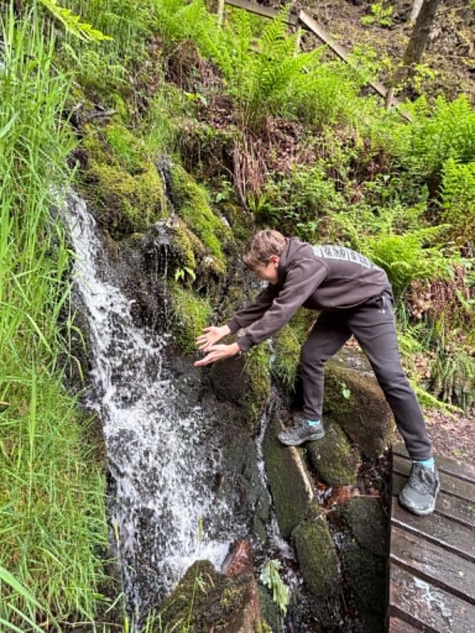 my eldest reaching out to a small waterfall