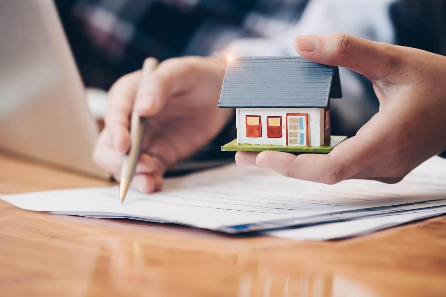 a small house being held as someone signs a contract