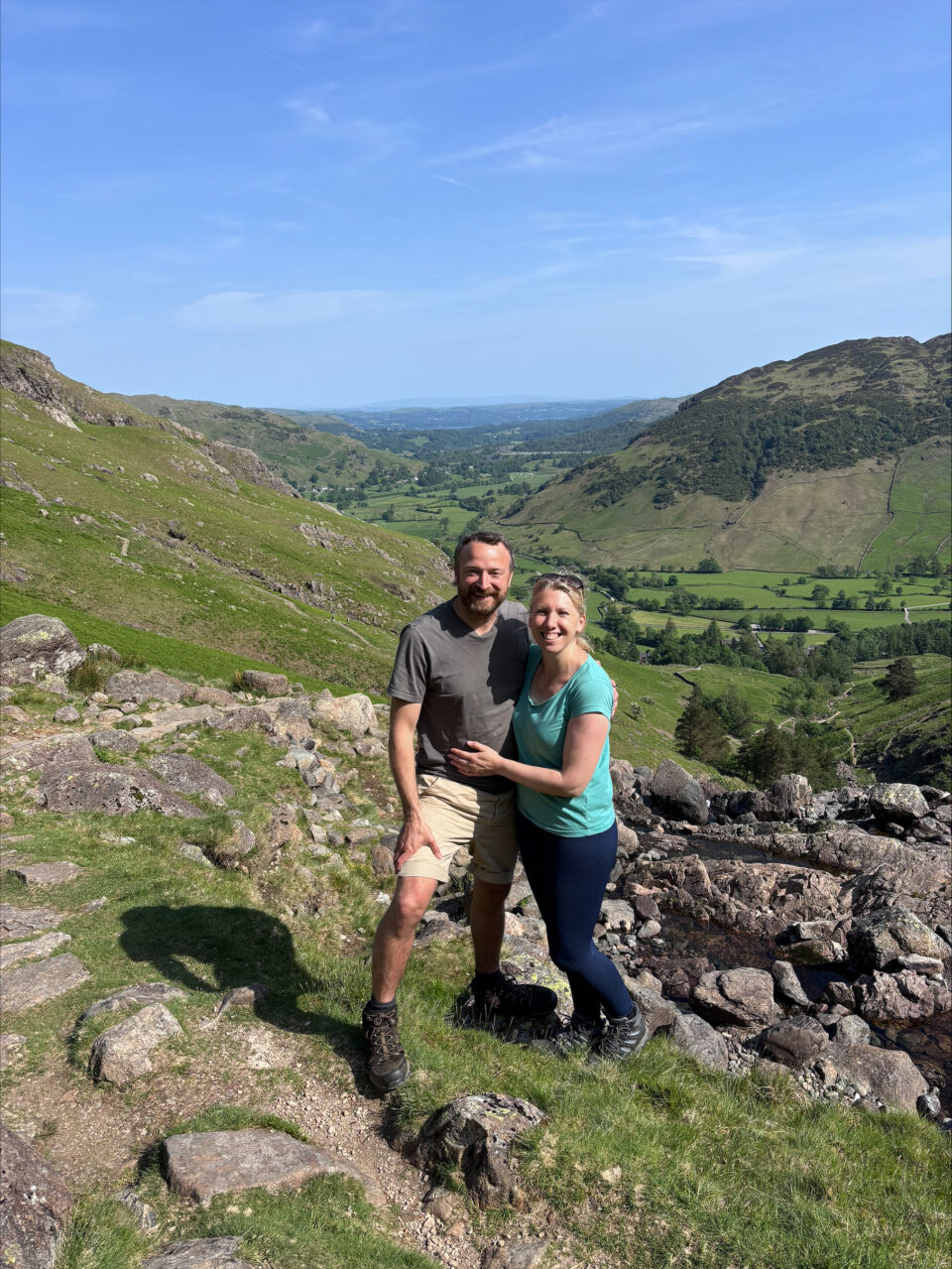 me and my husband having a stop on the way down Stickle Tarn with amazig views of hills and countryside in the background